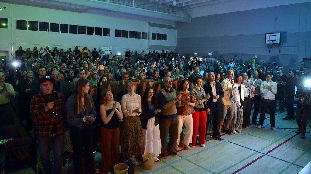 Suuri joukko vöyriläisiä seuraa KAJ'n finaaliesitystä Euroviisuissa juhlasalista käsin.