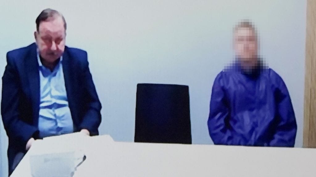 Kuvassa epäilty avustajansa kanssa.