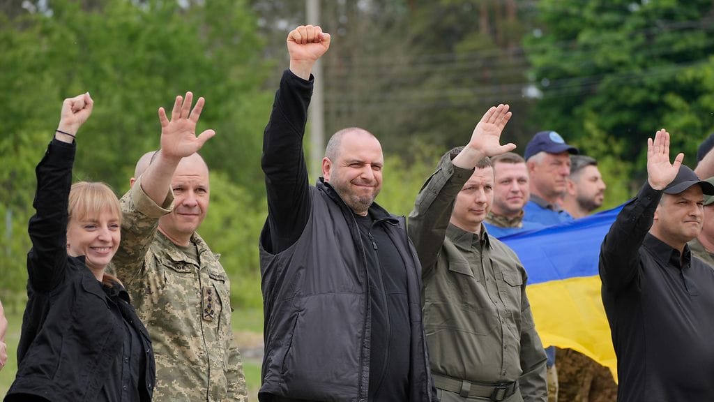 Ukrainalaiskomentajat ja puolustusministeri Rustem Umerov (keskellä) tervehtivät vapautettuja ukrainalaisia sotavankeja aiemmin tänä keväänä (toukokuussa 2025).