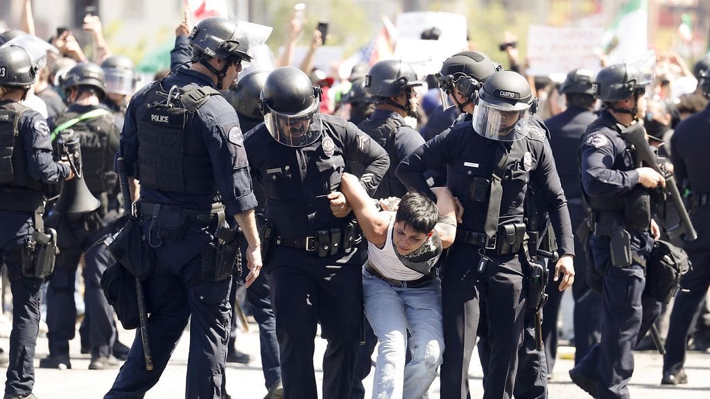 Los Angeles police officers arrest a person during protests near the Edward R. Roybal Federal Building in Los Angeles, California, USA, 08 June 2025.
