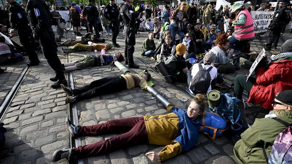 Poliisi joutui irrottamaan työkalun avulla mielenosoittajia toisistaan.