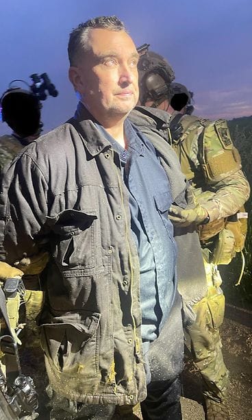 Maastopukuiset viranomaiset pitävät kiinni Minnesotan ampujasta.