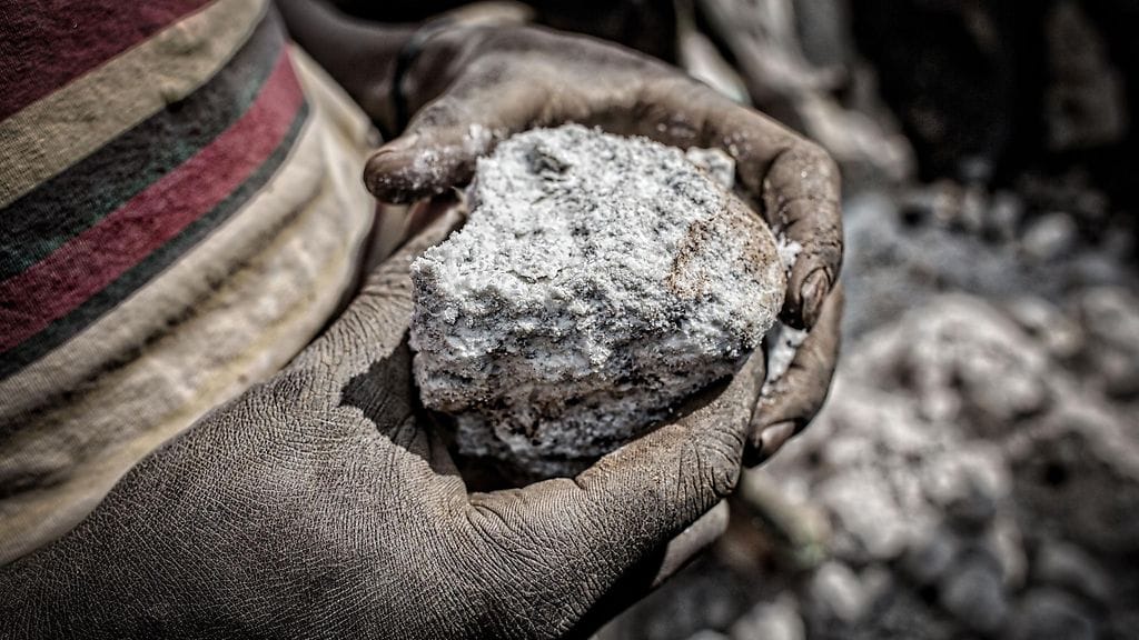 Kuvituskuvassa kaivostyöntekijä Rubayan koltaanikaivoksella pitelee käsissään manganiittia, jonka sisällä on koltaania. Koltaania käytetään esimerkiksi kännyköissä.