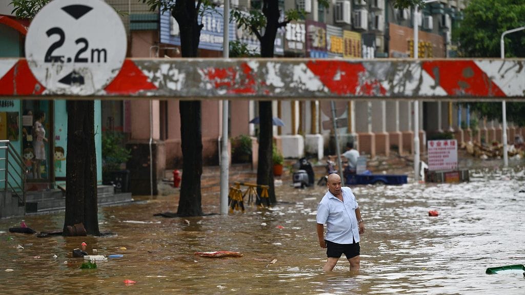 Mies käveli tiistaina tulvivan kadun läpi Zhongshanissa Kiinan eteläisessä Guangdongin maakunnassa.