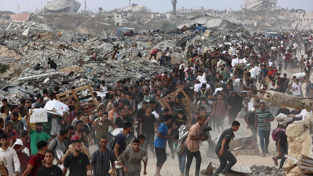 Ihmiset kantavat avustustarvikkeita Jabalian kaupungissa Gazan kaistalla 22. kesäkuuta sen jälkeen, kun humanitaarisen avun kuorma-autot saapuivat Pohjois-Gazan kaistalle Israelin valvoman Zikimin rajanylityspaikan kautta