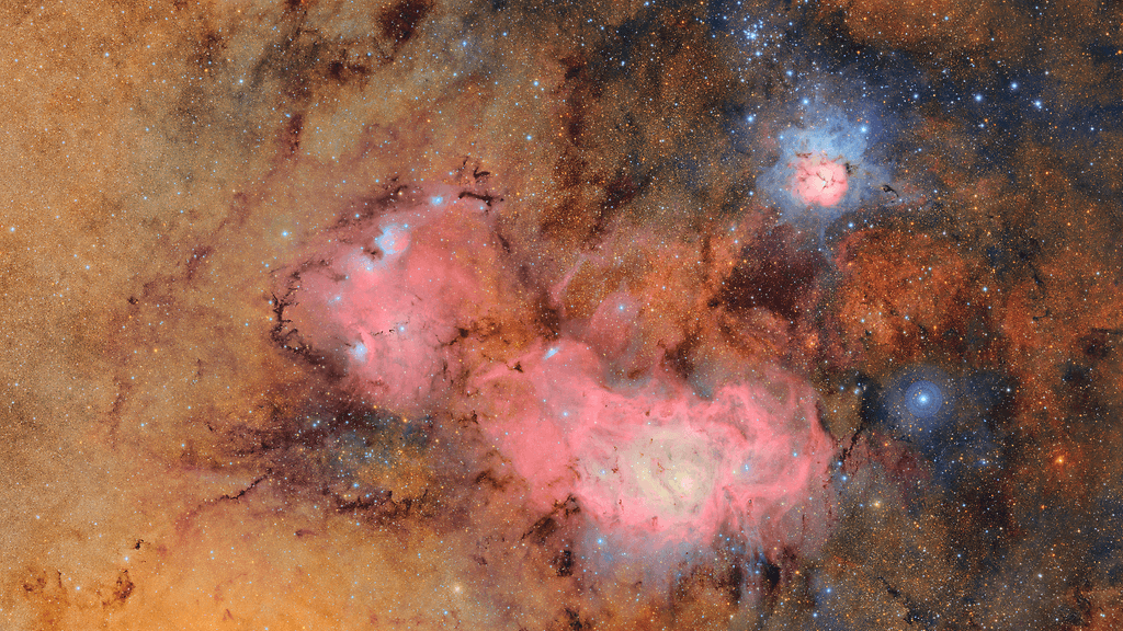 Tämä kuva yhdistää 678 erillistä kuvaa, jotka Vera Rubin Observatorio otti seitsemän tunnin aikana. Kuvien yhdistäminen paljastaa muutoin himmeät tai näkymättömät yksityiskohdat, kuten kaasu- ja pölypilvet. Kuvassa näkyy Trifid-sumu (ylhäällä) ja Laguunisumu, jotka ovat useiden tuhansien valovuosien päässä Maasta.