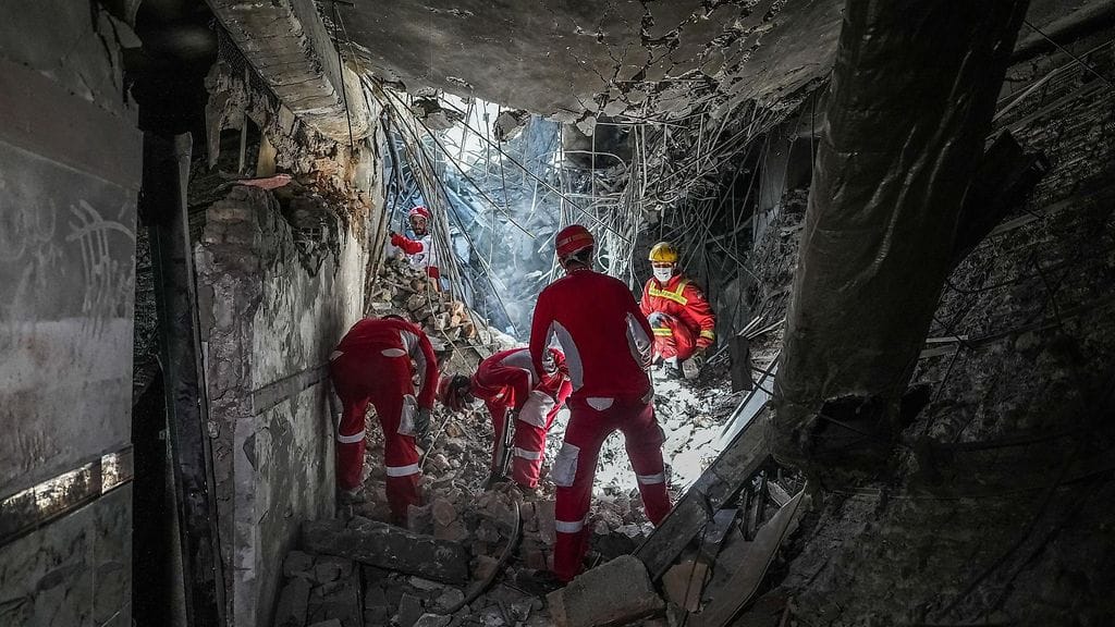 Pelastajia Teheranin Evinin vankilakompleksin raunioilla.