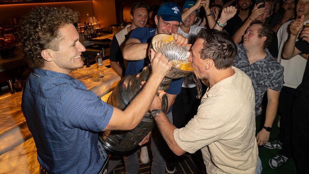 Matthew Tkachuk (vas.) ja Aleksander Barkov tarjoilivat Brad Marchandille (oik.) juomaa Stanley Cupista Panthersin mestaruusjuhlissa.