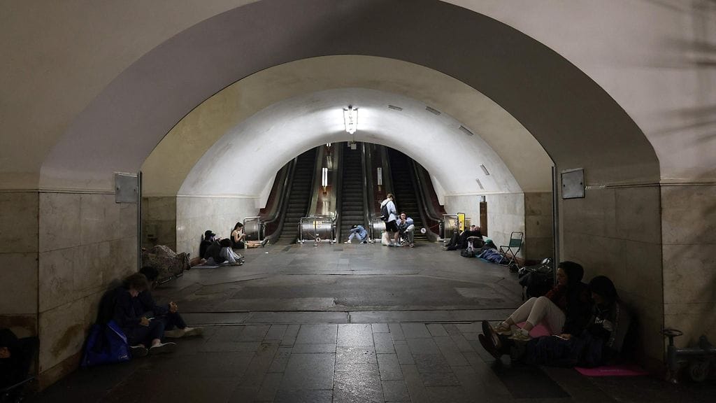 Ihmiset suojautuvat Venäjän öisiltä iskuilta metroaseman käytävillä Kiovassa.
