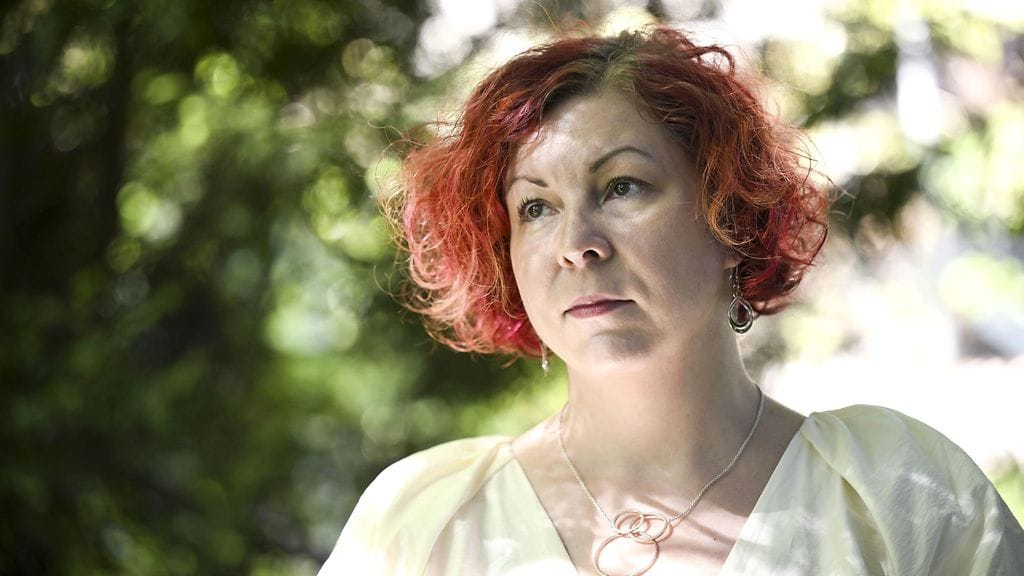 Punahiuksinen Heini Björk katsoo eteenpäin.