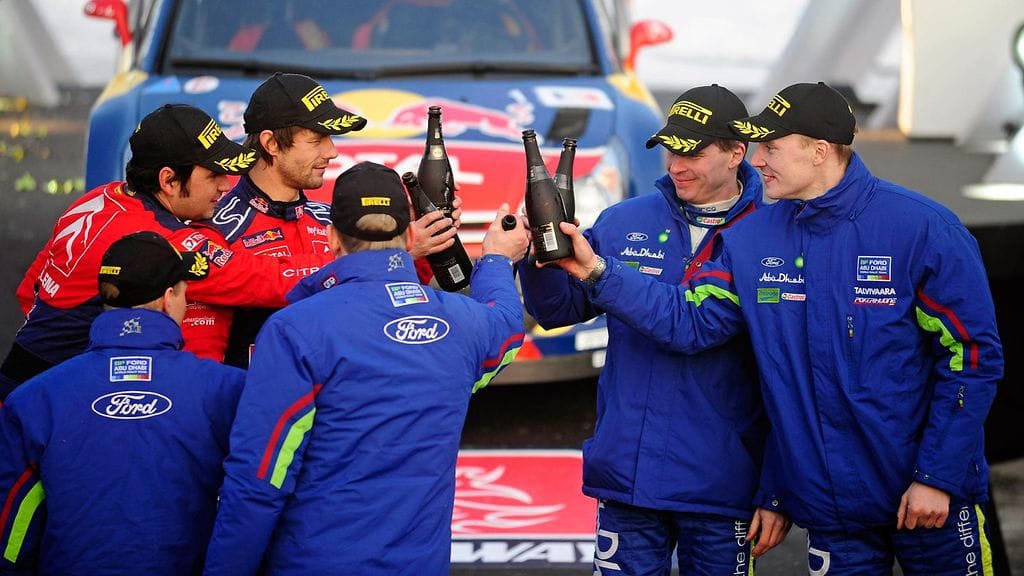 Sébastien Loeb (takana vas.) juhli voittoa Norjan MM-rallissa värikkäiden vaiheiden jälkeen. Jari-Matti Latvala (oik.) oli kolmas.