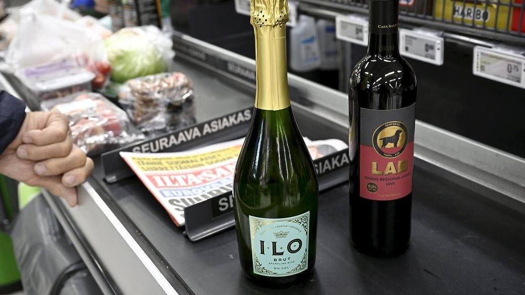 Viinipulloja kaupan kassahihnalla.