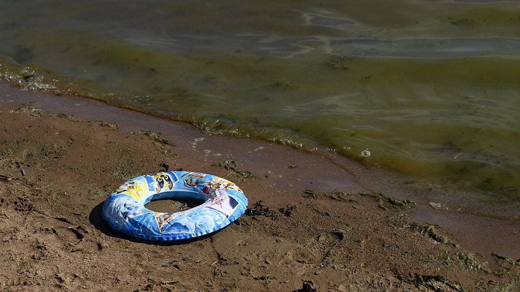 Pieni taapero jäi yksin rannalle, kun vanhemmat lähtivät uimaan. Kuvituskuva.