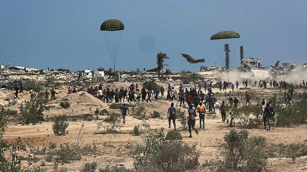 Palestiinalaiset ryntäävät noutamaan laskuvarjolla pudotettuja avustuspaketteja Nuseiratissa Gazan keskiosassa 9. elokuuta 2025.