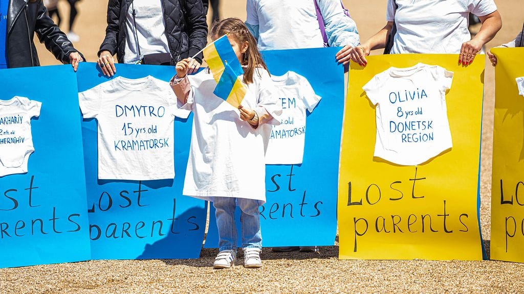 Kuvituskuva hyväntekeväisyysjärjestön tilaisuudesta, jossa kadonneiden ja menehtyneiden ukrainalaislasten nimiä ja ikiä oli kirjattu t-paitoihin.