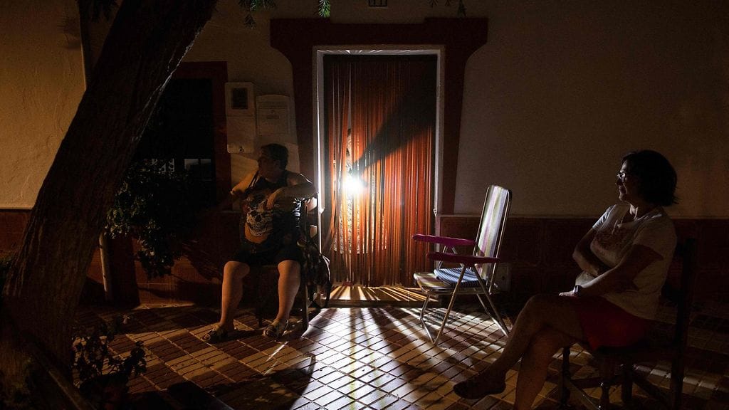 Ihmiset kerääntyivät ulos istumaan talojensa eteen viilentyäkseen helleaallon aikana Arriatessa 4. elokuuta 2025.