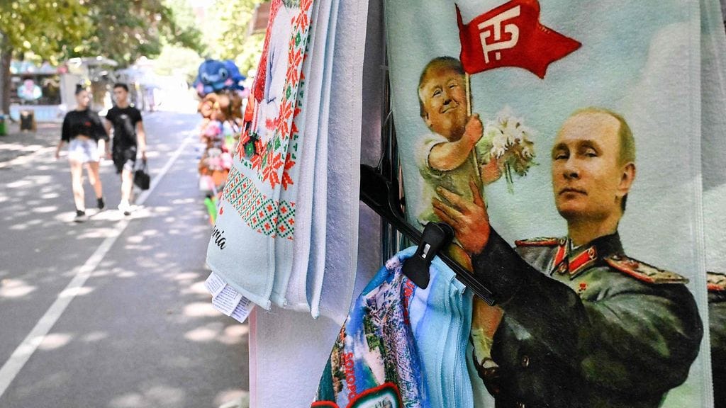 Kioskilla esillä Venäjän presidentin Vladimir Putinin ja Yhdysvaltain presidentin Donald Trumpin kuvalla varustettu rantapyyhe Mustanmeren lomakohteessa Albenassa 17. elokuuta.