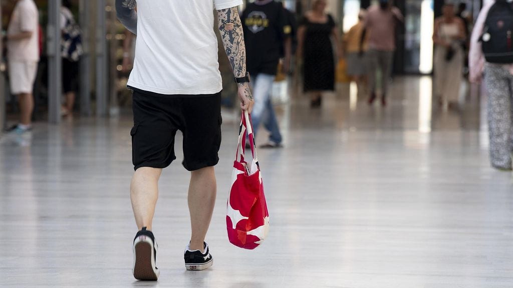 Ihminen kauppakassin kanssa Itäkeskuksen kauppakeskuksessa Helsingissä 25. heinäkuuta.