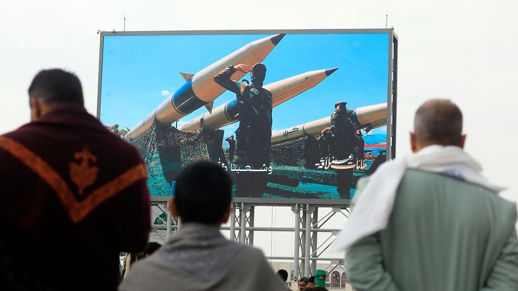 Huthien kannattajat seisovat digitaalisen mainostaulun edessä, jossa on kuvattu huthitaistelijoita ohjusten vieressä palestiinalaisten puolesta järjestetyssä mielenosoituksessa Sanaassa, Jemenissä, 22.8.2025.