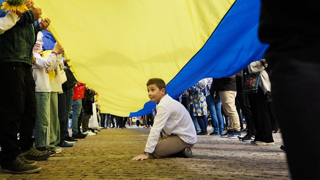 LK 24.8.2025 Matvii Nebeiseichuk Ukrainan lipun alla Ukrainan kansallispäivän United for Ukraine -tapahtumassa Senaatintorilla Helsingissä 24. elokuuta 2025.