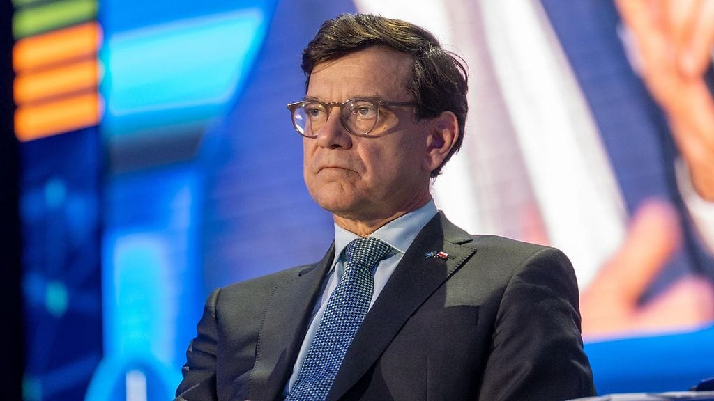 Henrik Landerholm istuu vakavana tiedotustilaisuudessa.