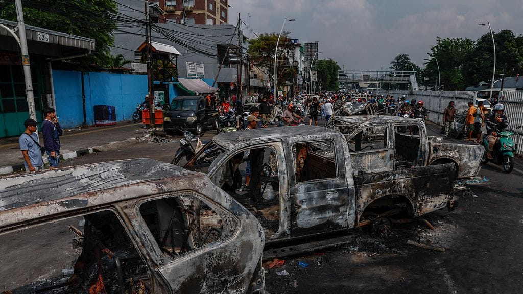 Mellakoissa poltettuja poliisiautoja Jakartassa.