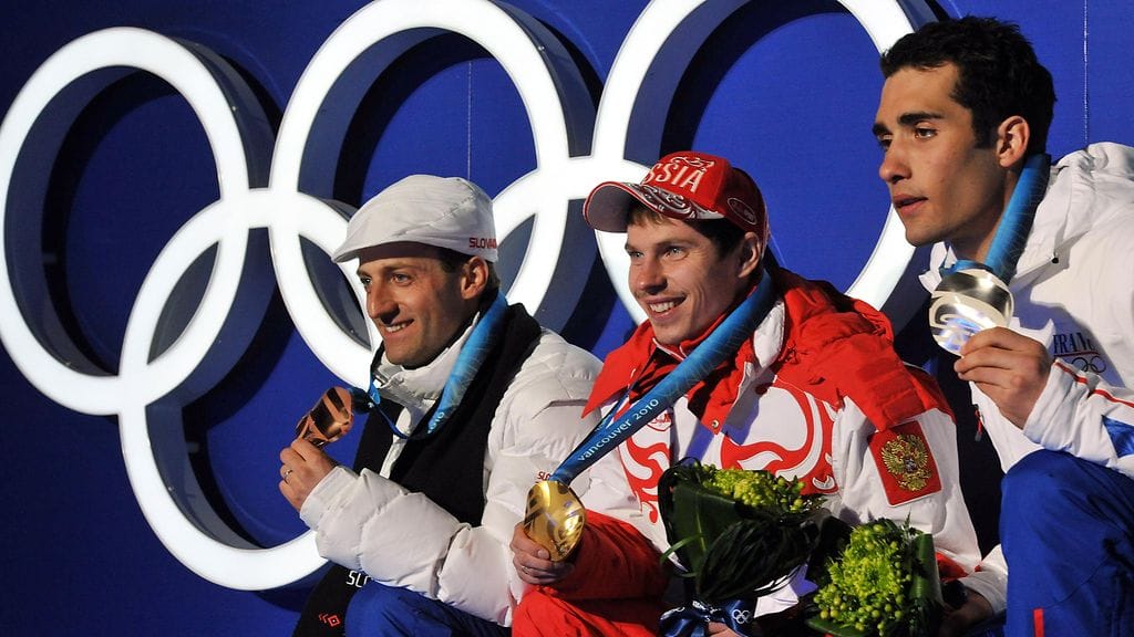 Jevgeni Ustjugovin (kesk.) kultamitali Vancouverin olympialaisten yhteislähtökisasta vuodelta 2010 menee nyt Ranskan Martin Fourcadelle (oik.).