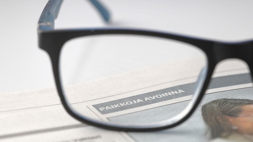 Kuvituskuvassa Karjalainen-lehden työpaikkailmoitussivusto ja lukulasit.