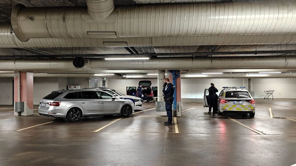 Poliisi tutkii autoa Myyrmannin kauppakeskuksen parkkihallissa.