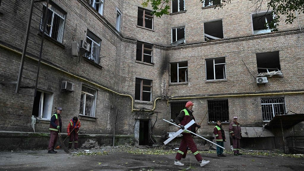 Pelastustyöntekijät siivosivat Kiovaan tehdyssä lennokki- ja ohjusiskussa vaurioituneen asuinrakennuksen pihaa keskiviikkona.