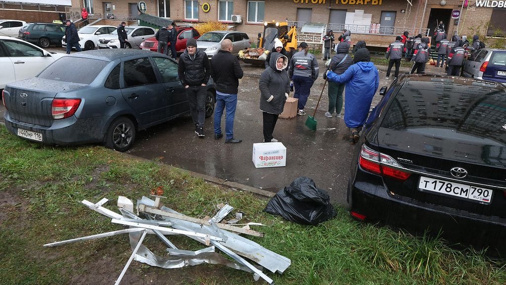 Työntekijät poistivat romua vaurioituneen kerrostalon edestä Ukrainan lennokki-iskun jälkeen Krasnogorskissa, Moskovan alueella, Venäjällä 24. lokakuuta.