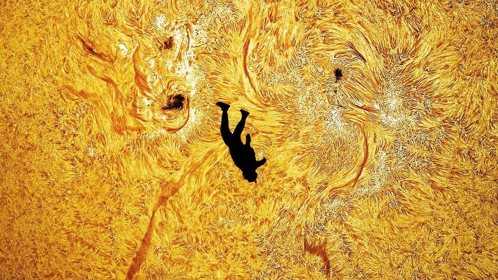 Avaruusvalokuvaaja Andrew McCarthyn kuvaama otos, jossa Aurinko näkyy huipputarkasti laskuvarjohyppääjän taustalla.