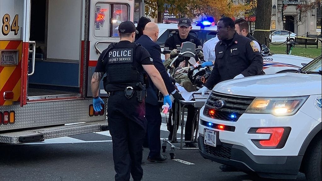 LK 26.11.2025 Sotilasasuinen mies makasi paareilla ja häntä kuljetettiin ambulanssiin 26. marraskuuta 2025 Washingtonin keskustassa.
