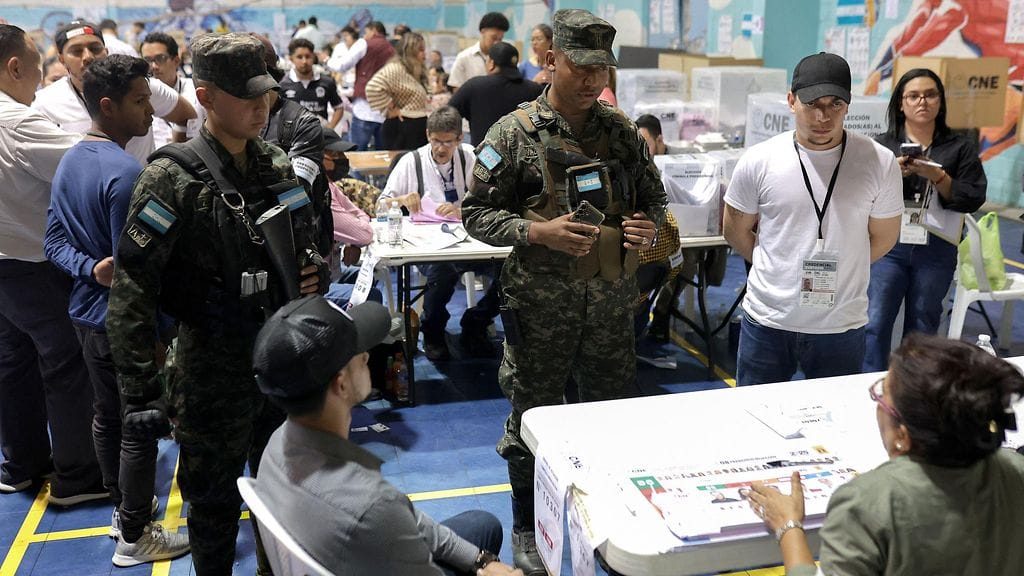 Kuvassa Hondurasin armeijan sotilaat puhuvat vaaliviranomaisten kanssa äänestyspaikalla Tegucigalpassa 30. marraskuuta 2025.