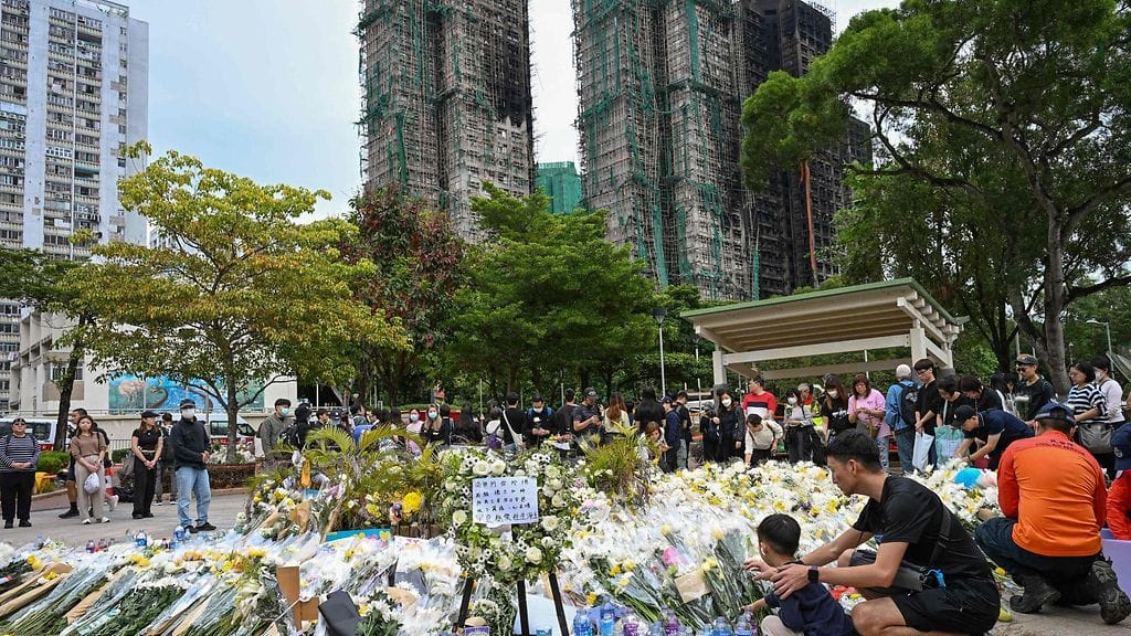 Menehtyneiden muistoksi oli tuotu kukkia kadulle Hongkongissa 2. joulukuuta 2025.