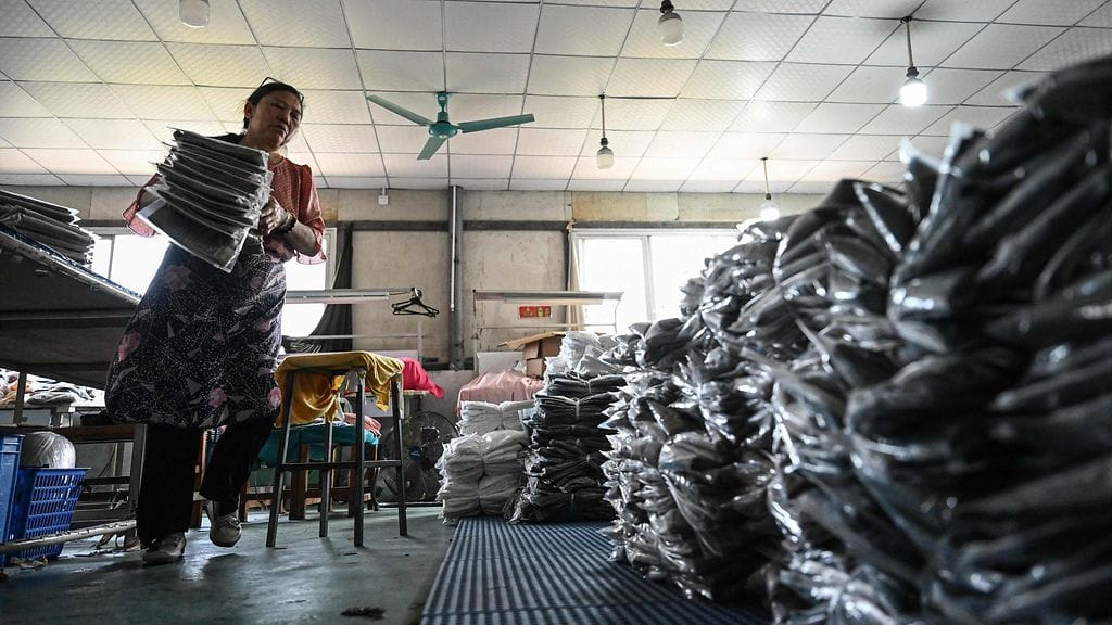 Työntekijä Temun vaatetehtaalla Kiinan Guangzhoussa huhtikuussa 2025.