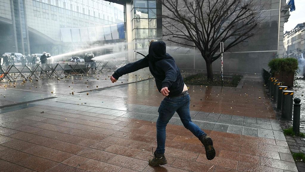 Maanviljelijä heitti perunoita poliisia kohti Euroopan parlamentin ulkopuolella 18. joulukuuta 2025.
