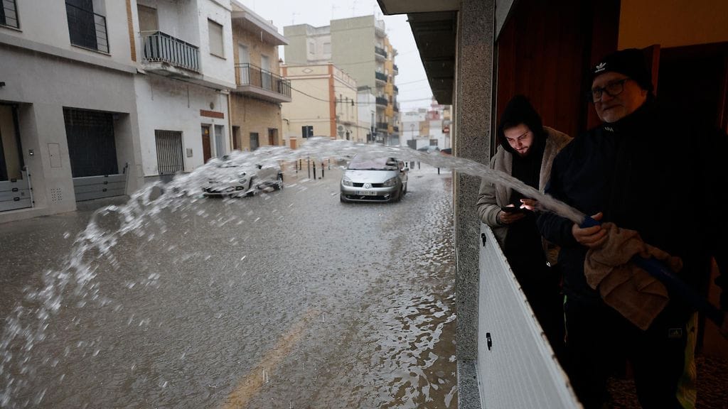 Mies poistaa autotalliinsa kertynyttä vettä rankkasateiden jälkeen Alcudiassa, Valenciassa, Espanjassa, 28. joulukuuta 2025.