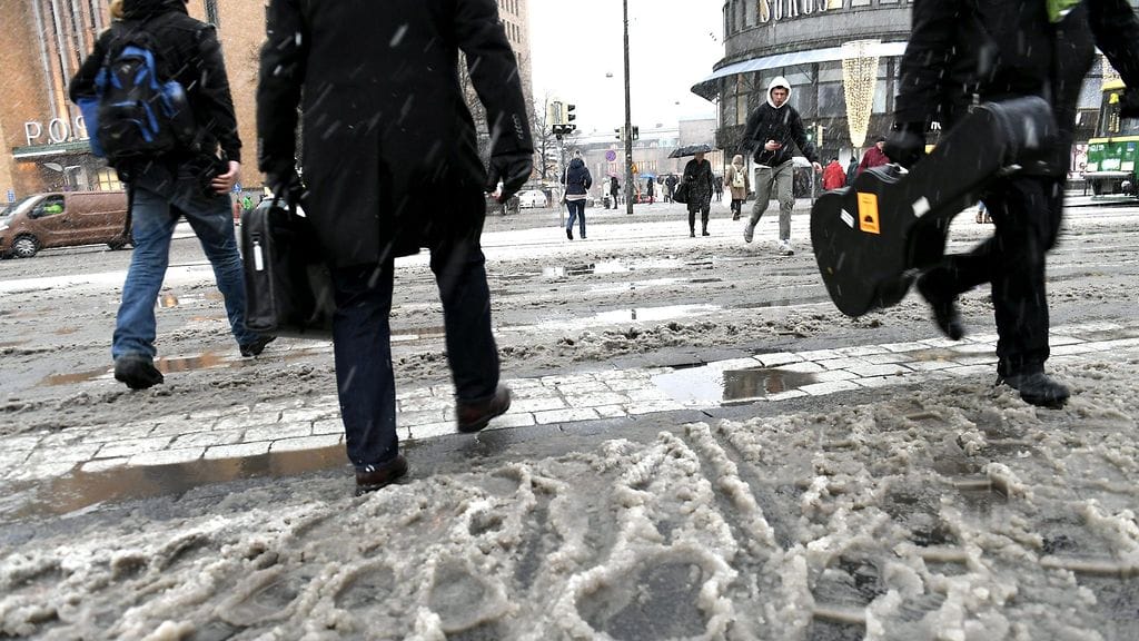 Kuvituskuvassa jalankulkijoita loskassa ja räntäsateessa Helsingin keskustassa joulukuussa 2017.