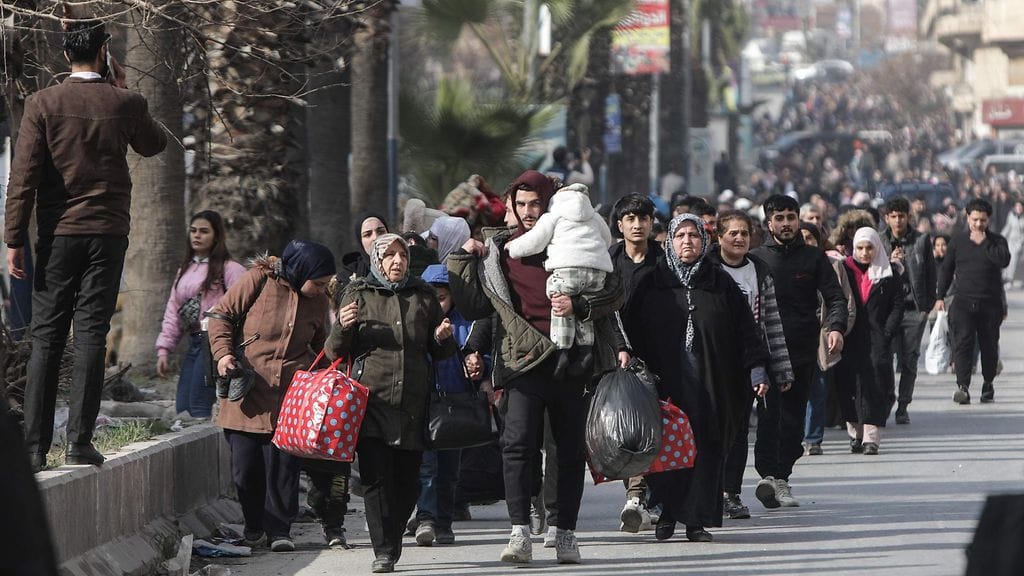 Asukkaat kantavat tavaroitaan paetessaan Aleppon Ashrafiehista keskiviikkona.