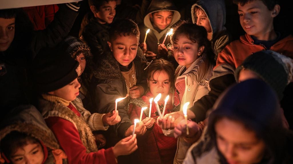 Lapset pitelivät käsissään toiveitaan ja unelmiaan uudelle vuodelle edustavia kynttilöitä ja banderolleja Gazan kaupungissa uudenvuodenaattona.