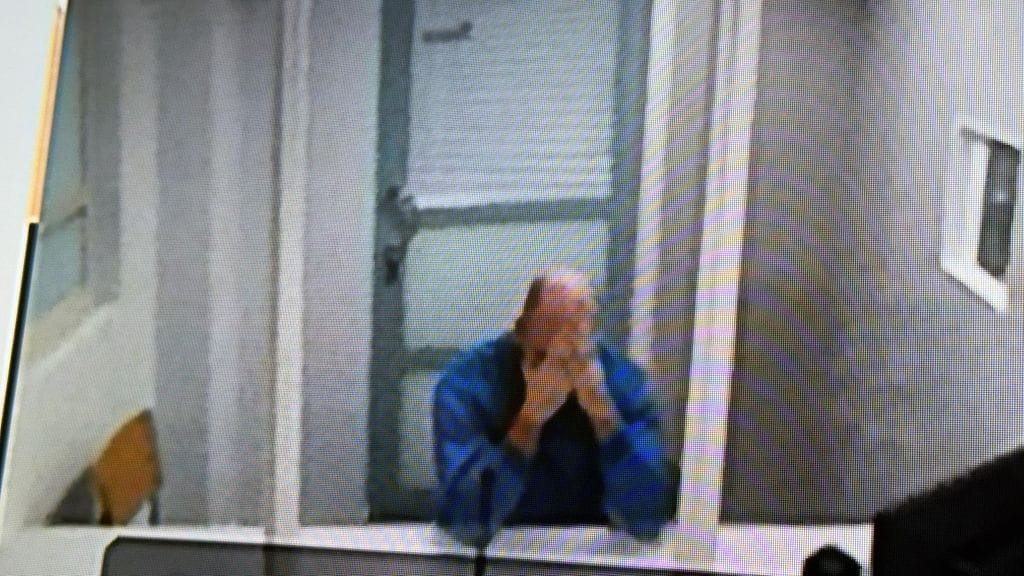 Mies kätki kasvonsa käsiinsä vangitsemisoikeudenkäynnissä.