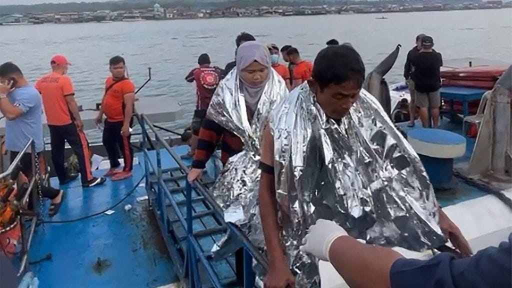 Pelastajat auttavat lauttaonnettomuudesta selvinneitä Filippiineillä 26. tammikuuta. Kuvakaappaus on otettu kuvernööri Mujiv Hatamanin toimittamasta videomateiaalista.