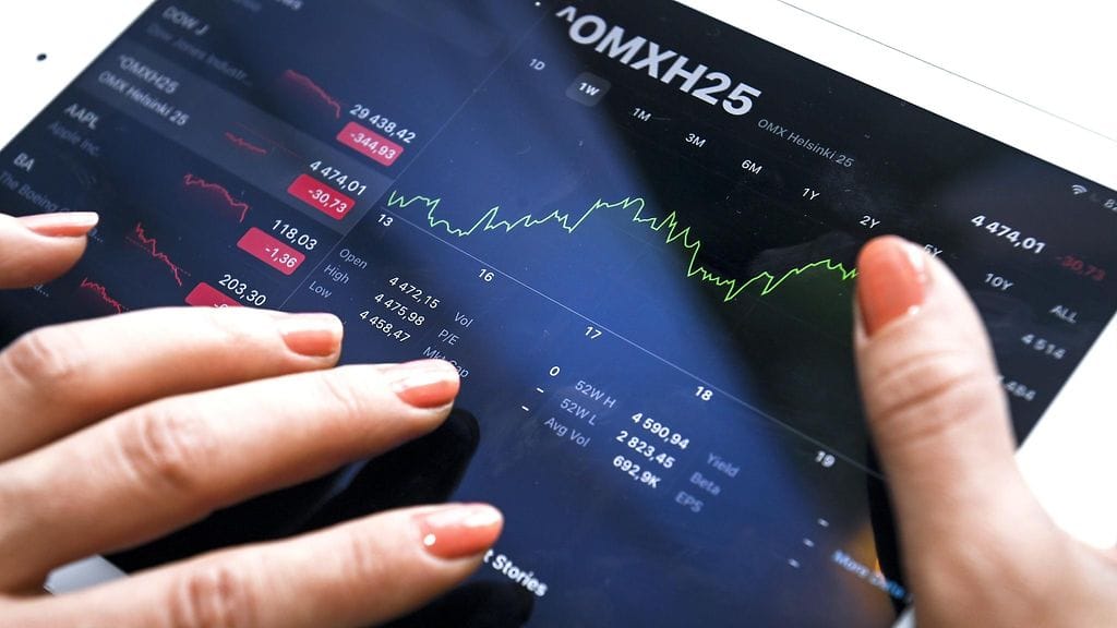 Sijoittamista harkitseva nainen tutki pörssikursseja Helsingissä 2020. Kuvituskuva.