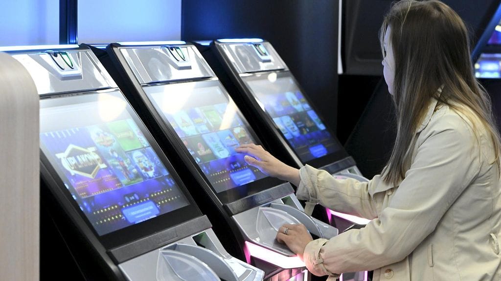 Nainen rahapeliautomaatilla Veikkauksen pelisalissa Helsingissä toukokuussa 2023.