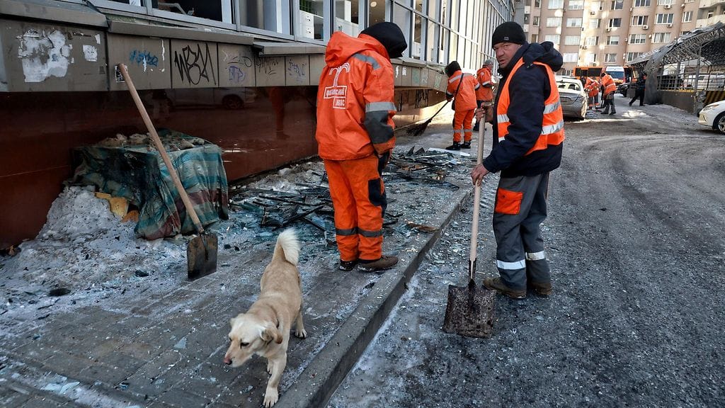 Koira pysytteli Venäjän drone-iskusta aiheutuneita romuja siivoavien työntekijöiden lähettyvillä Odessassa, Ukrainassa, 9. helmikuuta 2026.