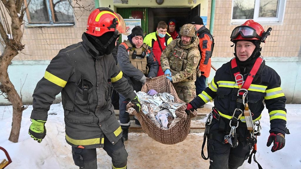 Ukrainalaiset pelastustyöntekijät evakuoivat asukkaan vaurioituneesta rakennuksesta ilmaiskujen jälkeen Harkovassa 3. helmikuuta. Venäjä on jälleen kiihdyttänyt iskujaan alueella.