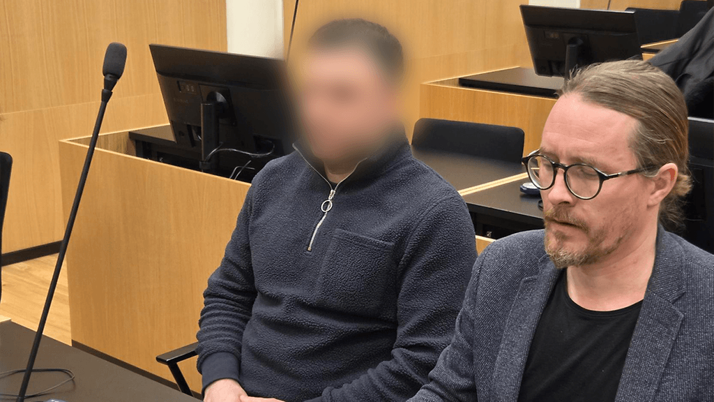 Murhasta syytetty mies ei peitellyt kasvojaan oikeudessa. Vieressä miehen avustaja.