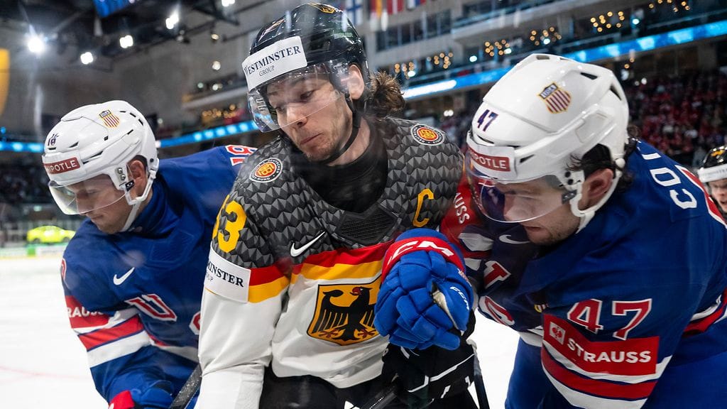 Saksan kapteeni Moritz Seider vääntämässä USA:n Sam Laffertya (vas.) ja Paul Cotteria vastaan.
