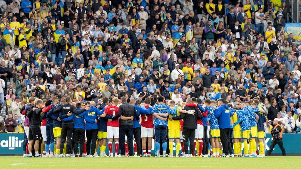 Tanskan ja Ukrainan joukkueiden jäsenet muodostivat Christian Eriksenin ympärille ringin.
